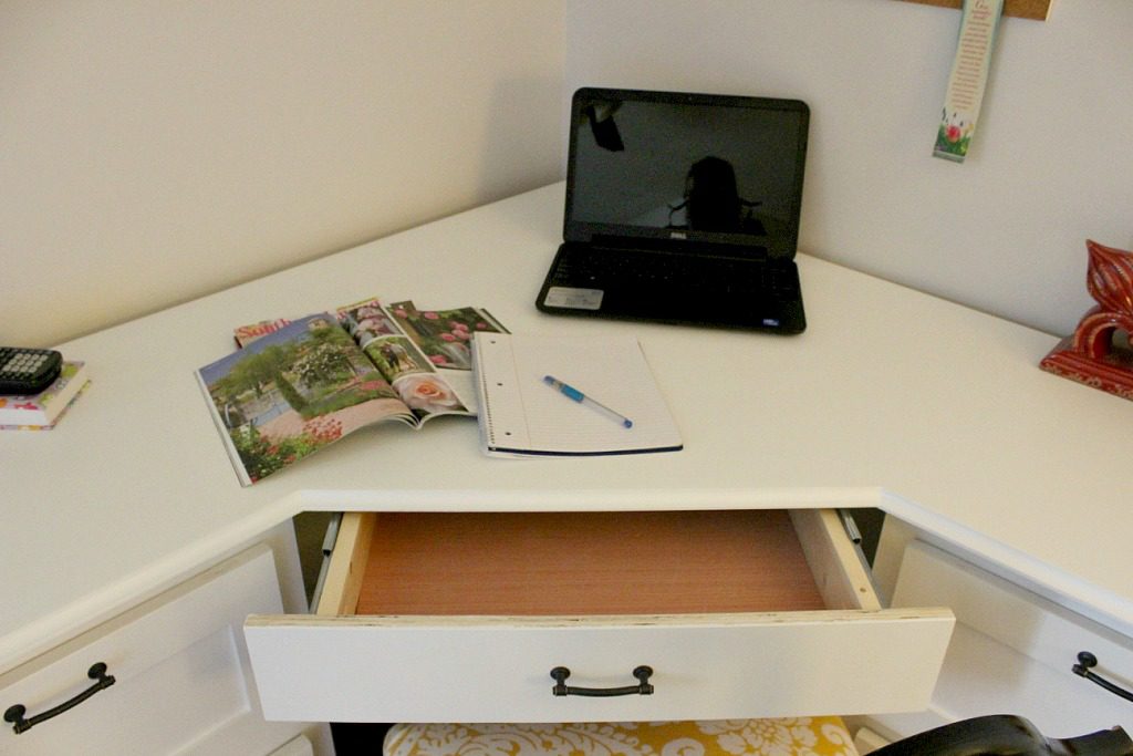 Close up view of middle drawer of desk open
