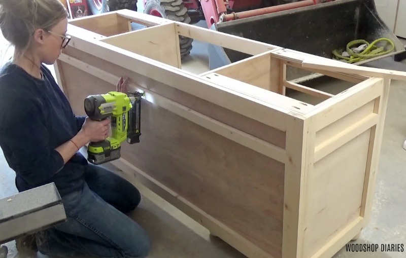 Shara Woodshop Diaries nailing trim around front of DIY desk