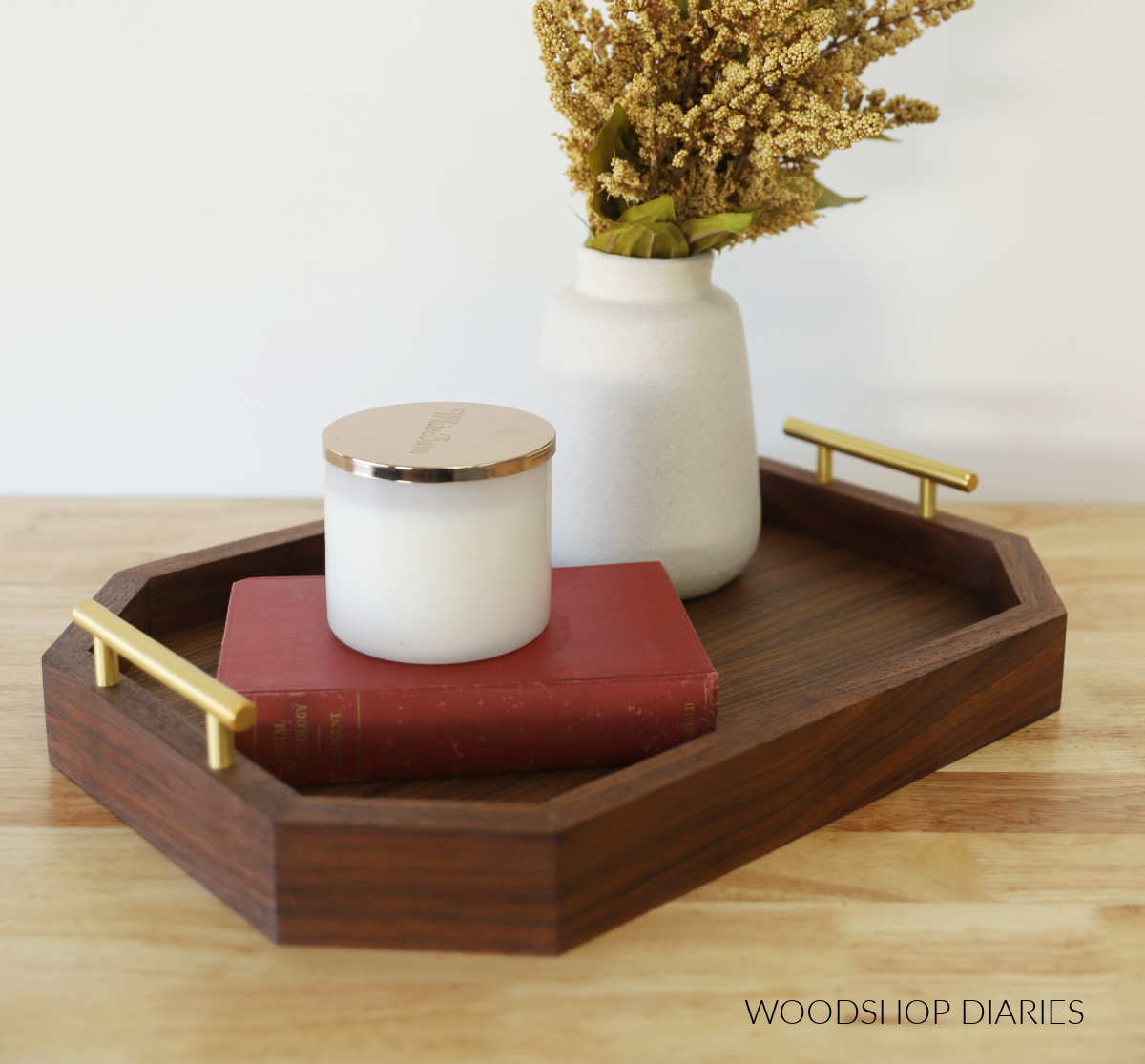 Modern DIY walnut serving tray with brass handles finished on countertop with vase, book and candle
