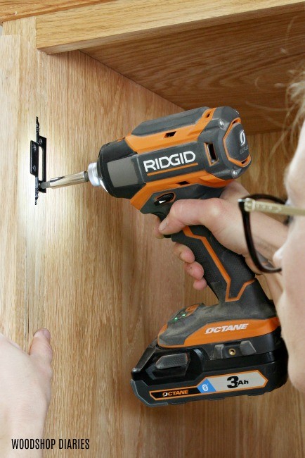 Close up of installing butt hinges to attach linen cabinet door