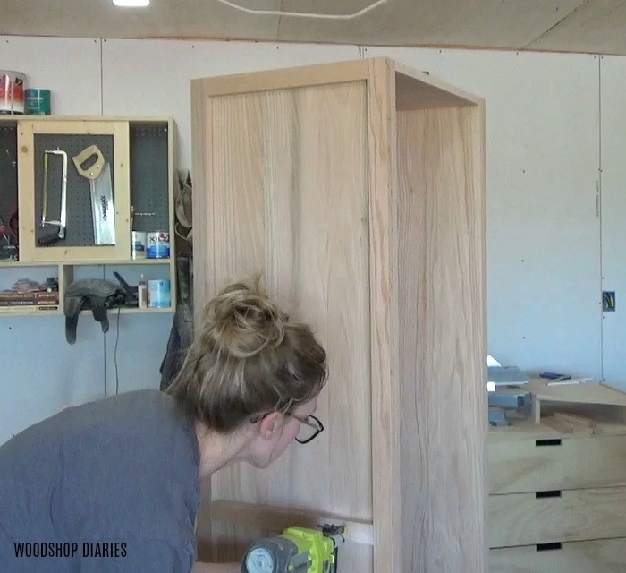 Shara Woodshop Diaries nailing trim onto sides of linen cabinet build