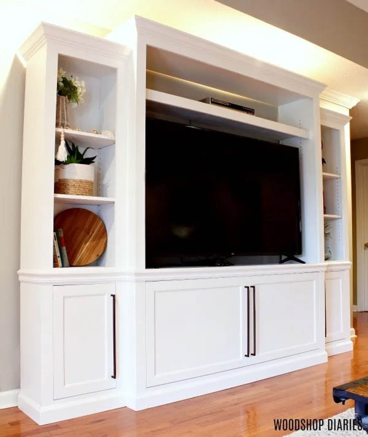 DIY Entertainment center in living room painted white with shelving and cabinetry