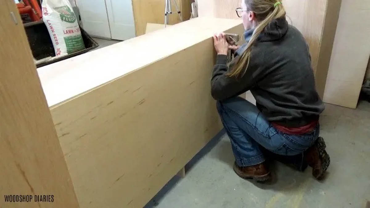 Shara Woodshop Diaries attaching backing onto middle entertainment center cabinet 
