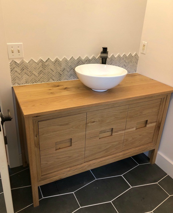Baseboards installed around vanity legs