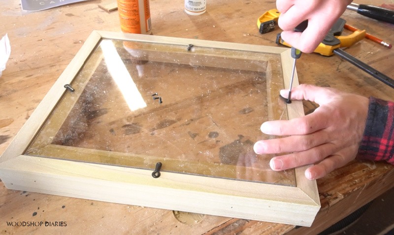 Screwing turn buttons onto back of easy DIY floating picture frame