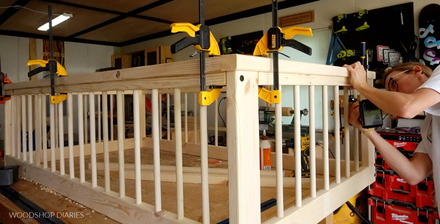 Close up of Shara Woodshop Diaries attaching top bed rails around floor bed frame