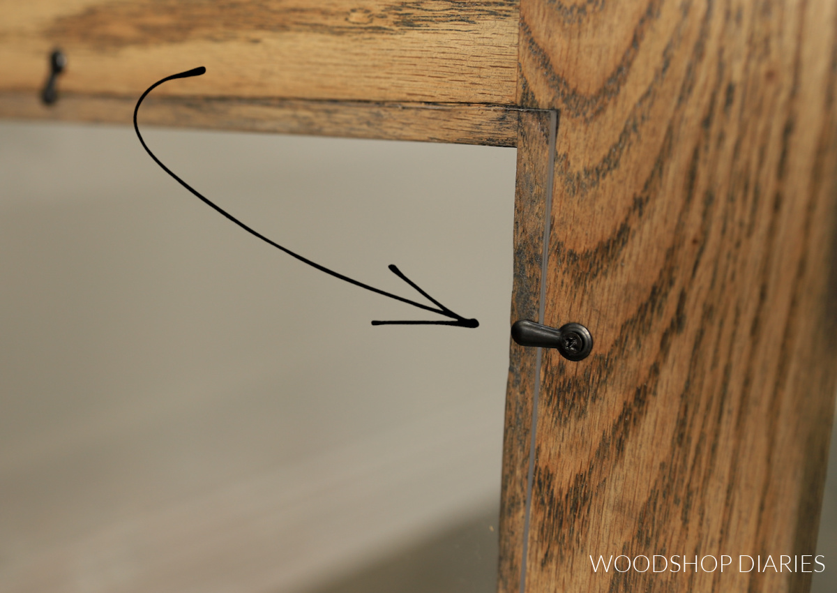 Close up of picture frame turn button used to hold plexiglass in door frame