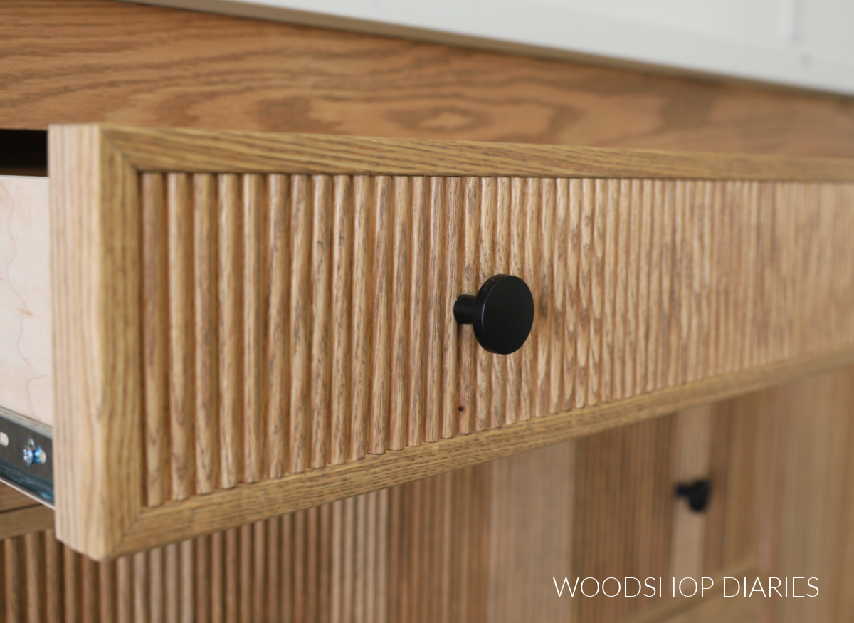 Close up of black knob on fluted drawer front