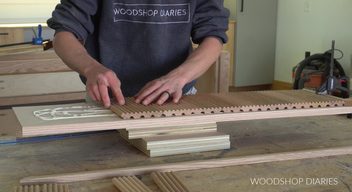 Shara Woodshop Diaries gluing fluted drawer front trim onto plywood panel