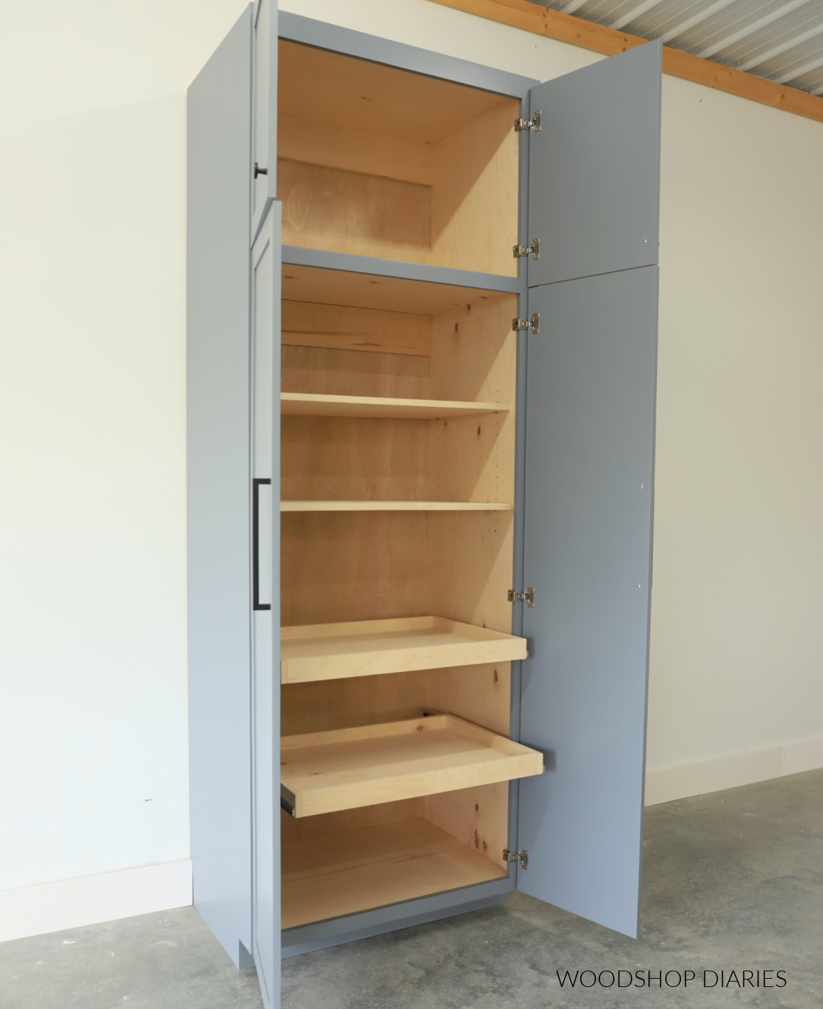 Pantry cabinet with doors open showing adjustable shelves and pull out drawer shelves inside
