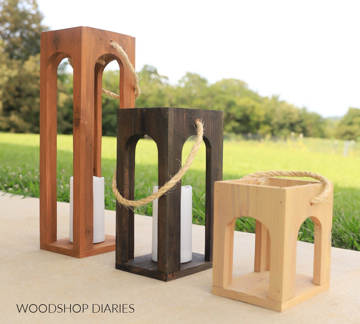 three lanterns of different size and color with arched sides on porch