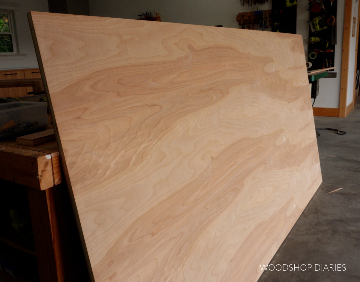 Sheet of birch plywood leaned against workbench in workshop