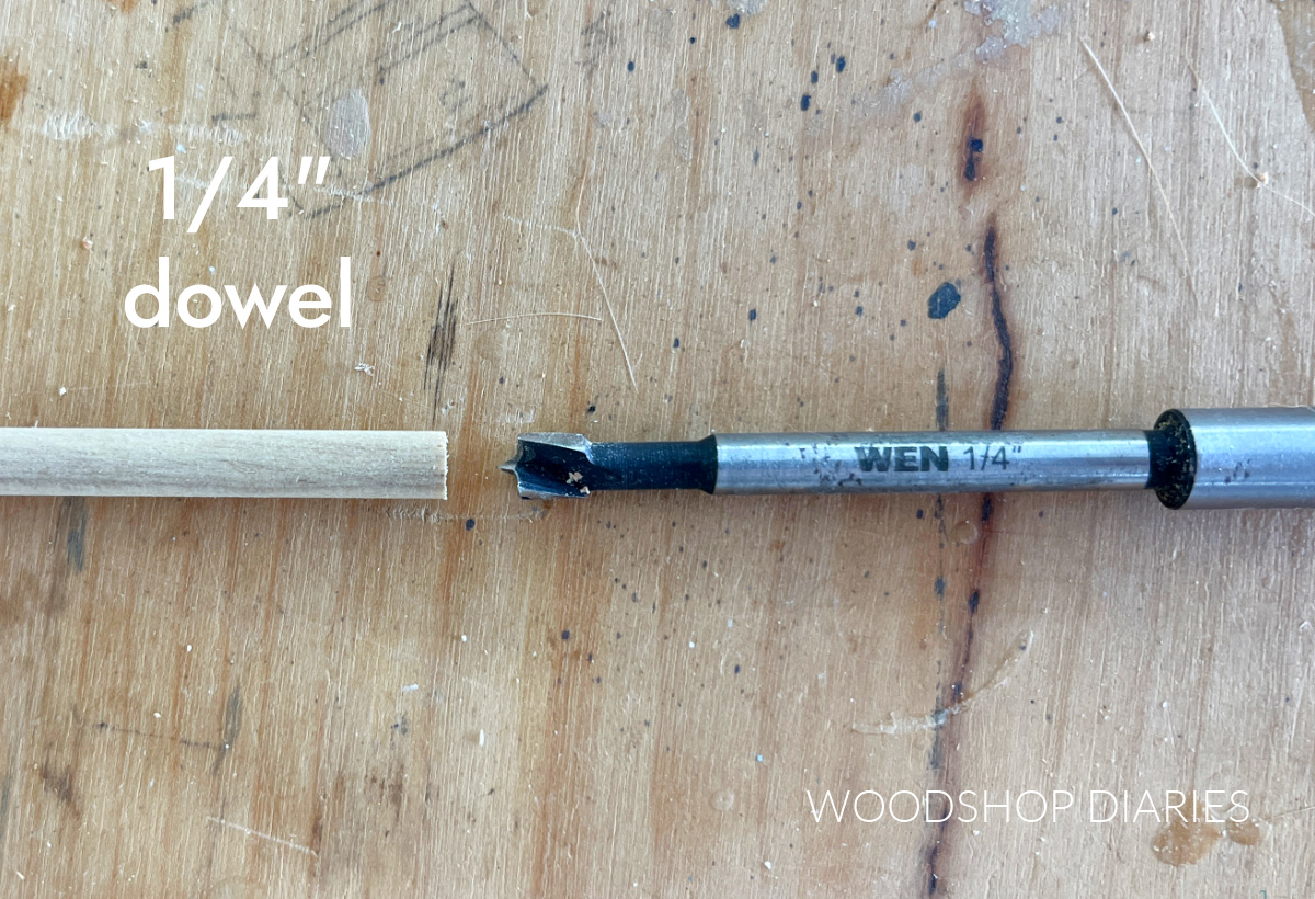 Close up of ¼" dowel rod next to ¼" Forstner bit on workbench