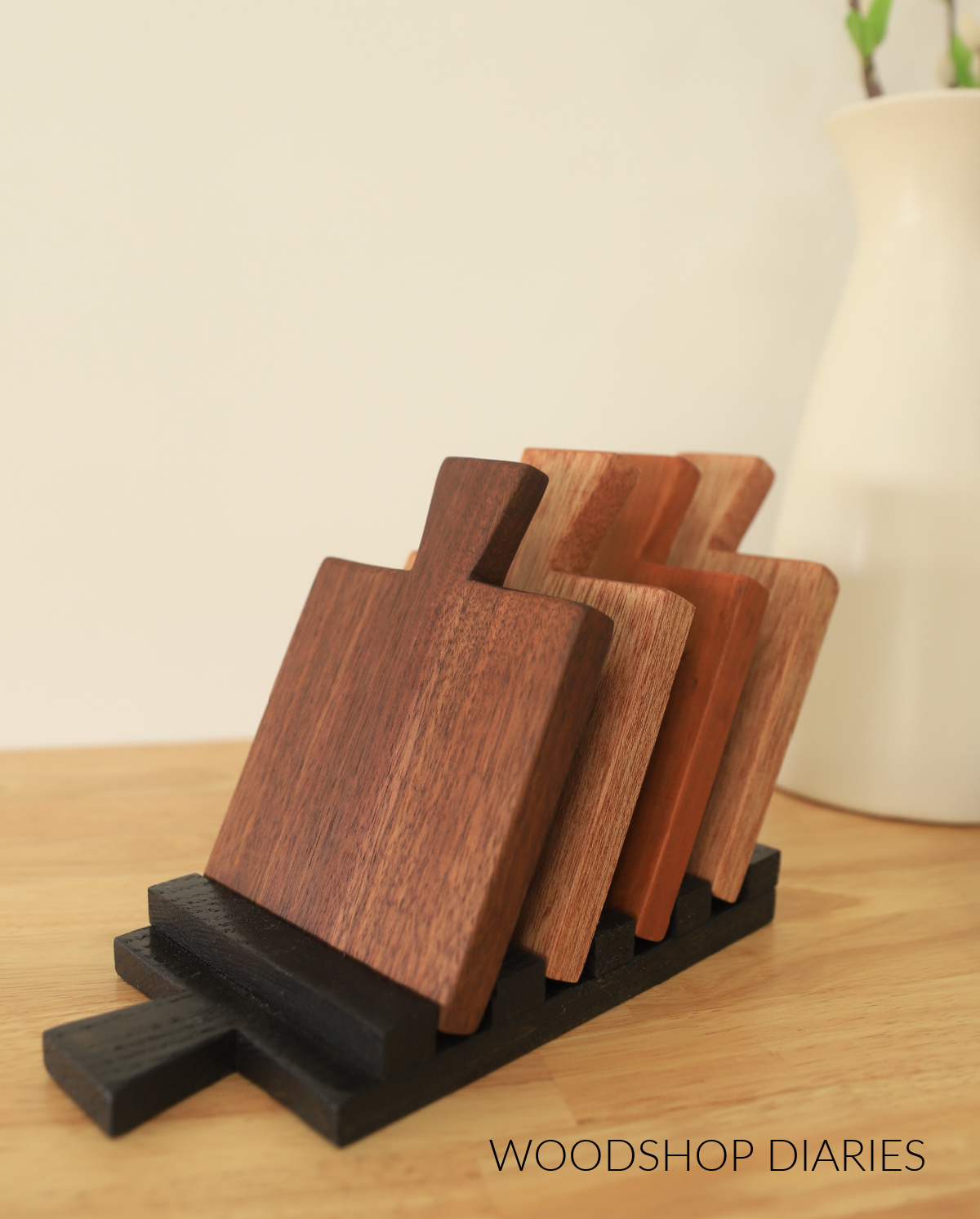 DIY wooden drink coaster set with all four coasters standing in coaster tray