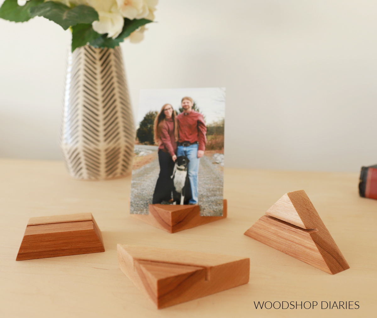 Scrap wood blocks cut into triangles for DIY photo stands with photo in one next to vase