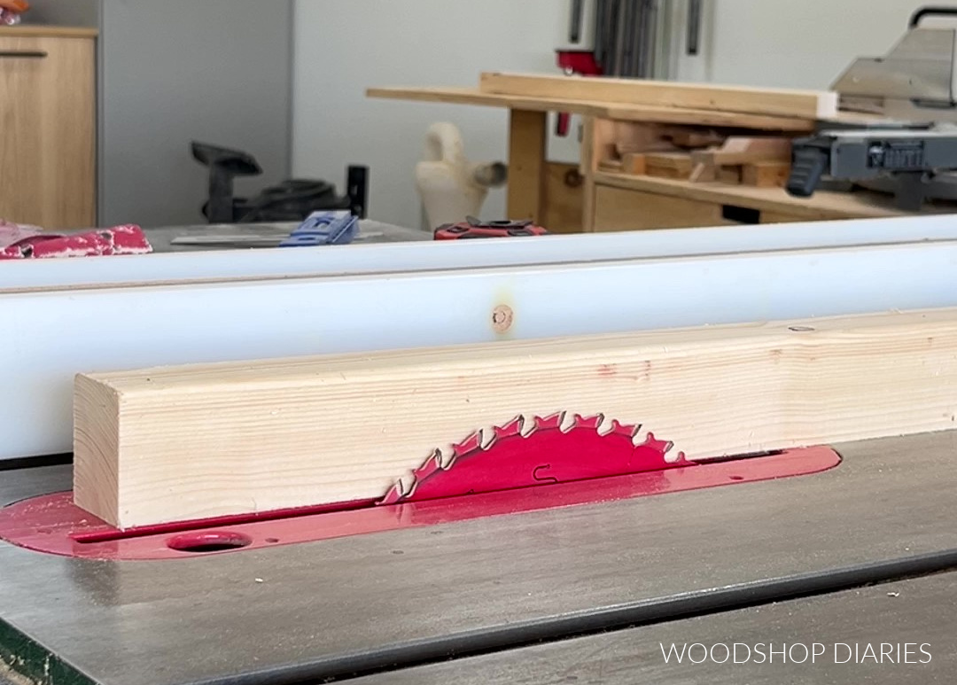 2x2 board next to table saw blade showing approximate blade height for photo stand slot cut