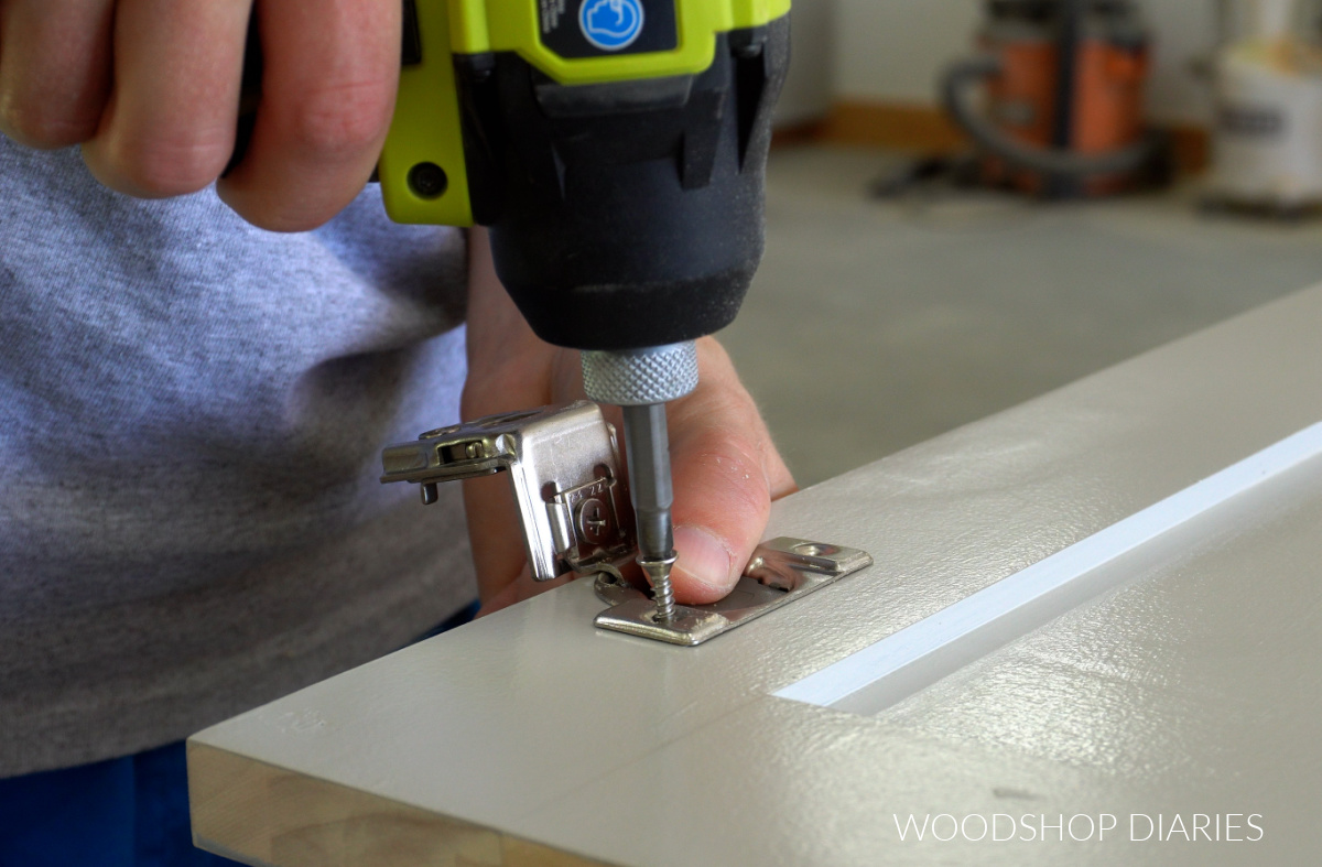Close up installing concealed hinge onto cabinet door
