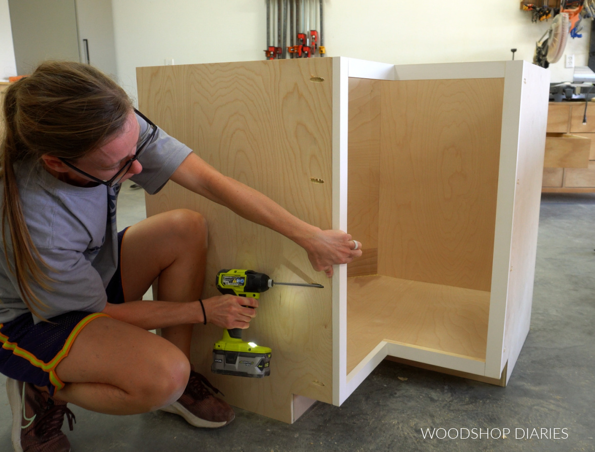 Shara Woodshop Diaries screwing face frame onto front of corner base cabinet