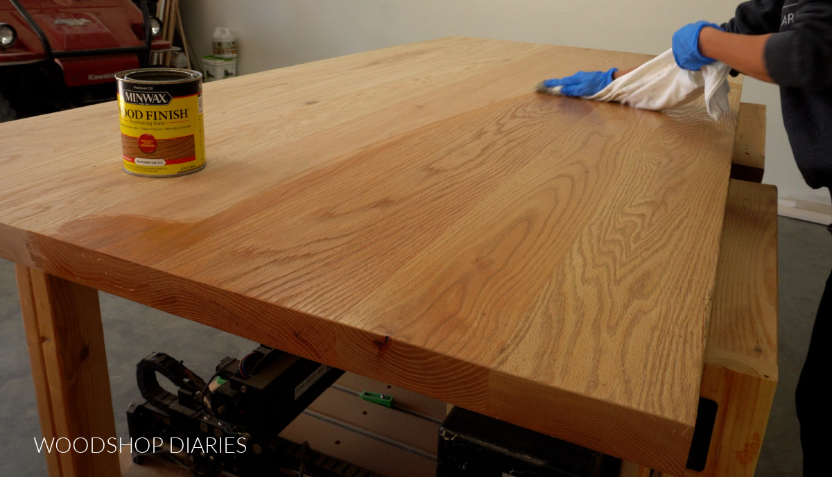 Applying wood stain to large red oak dining table top