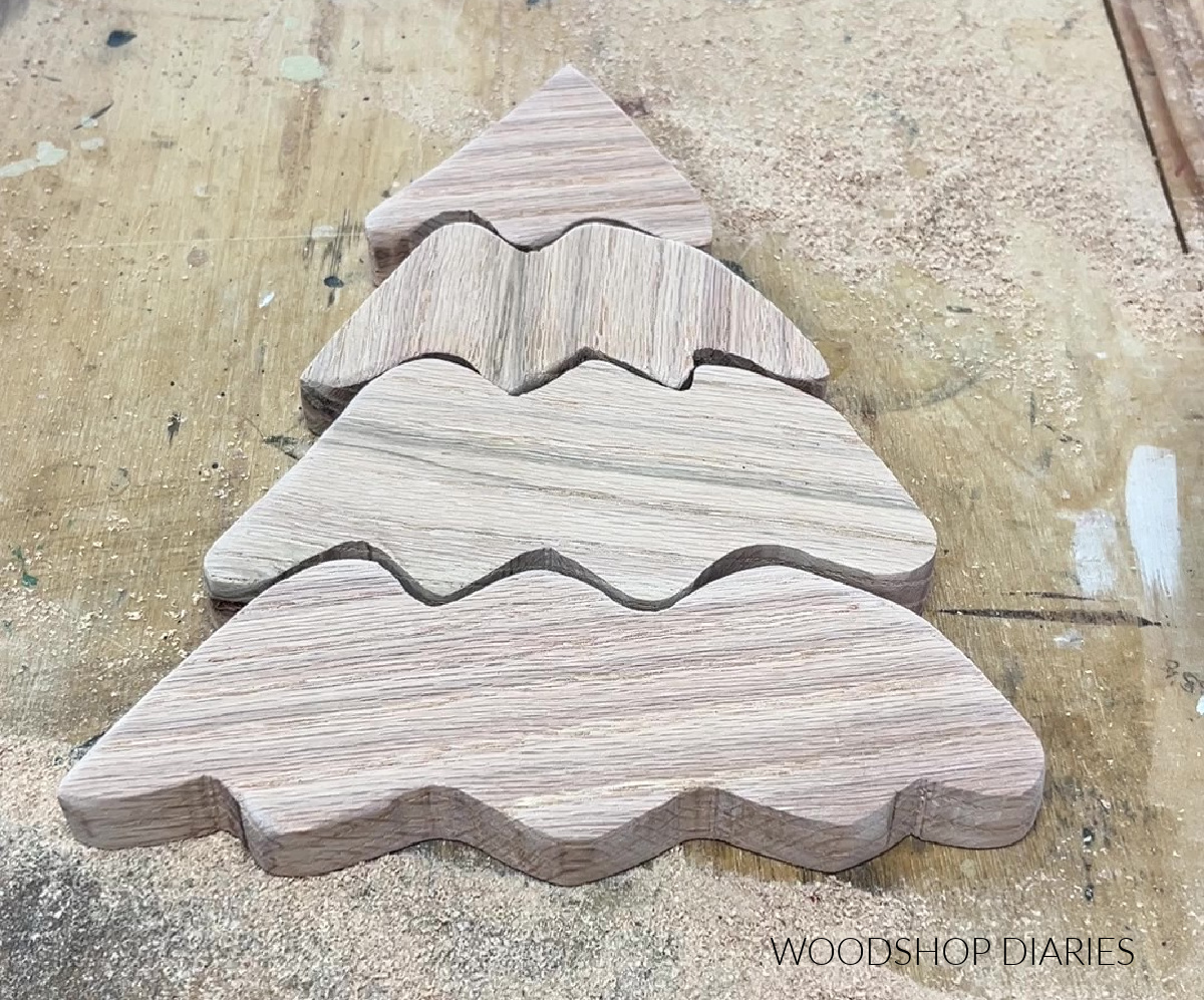 Christmas tree wood art cut out in pieces laid out on workbench