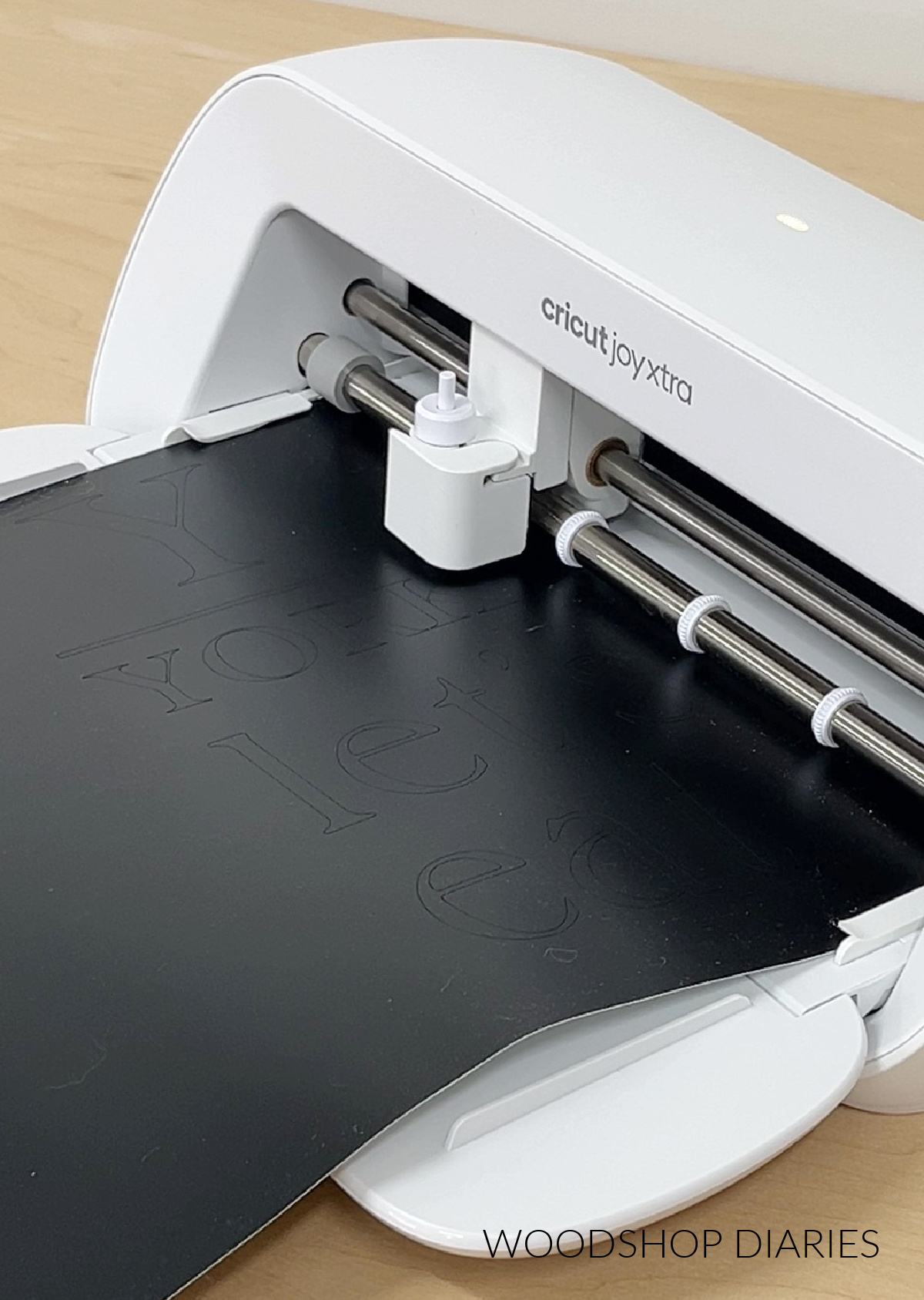 Close up of Cricut Joy Xtra cutting vinyl stencils for serving boards