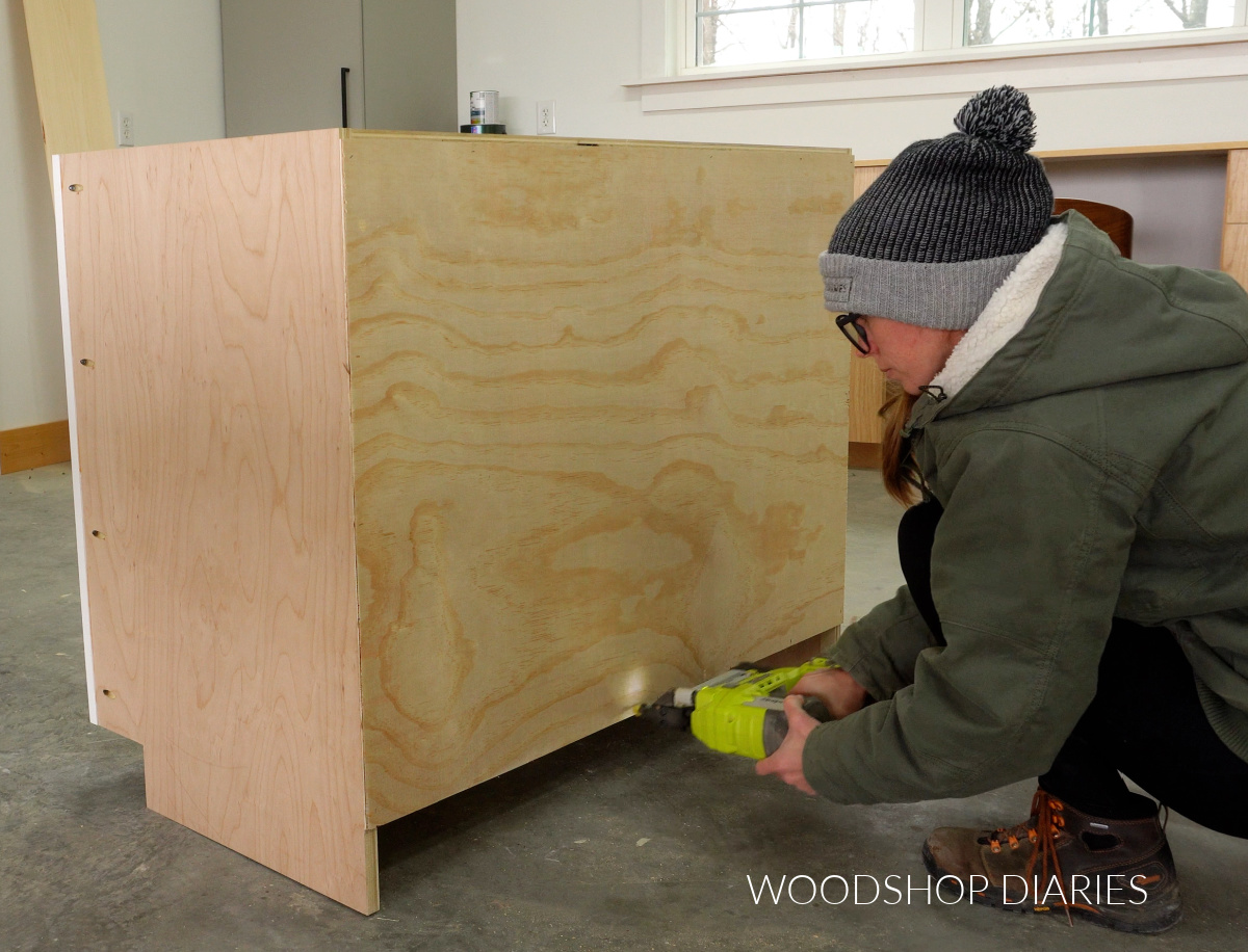 Shara Woodshop Diaries stapling back panel onto blind corner cabinet box