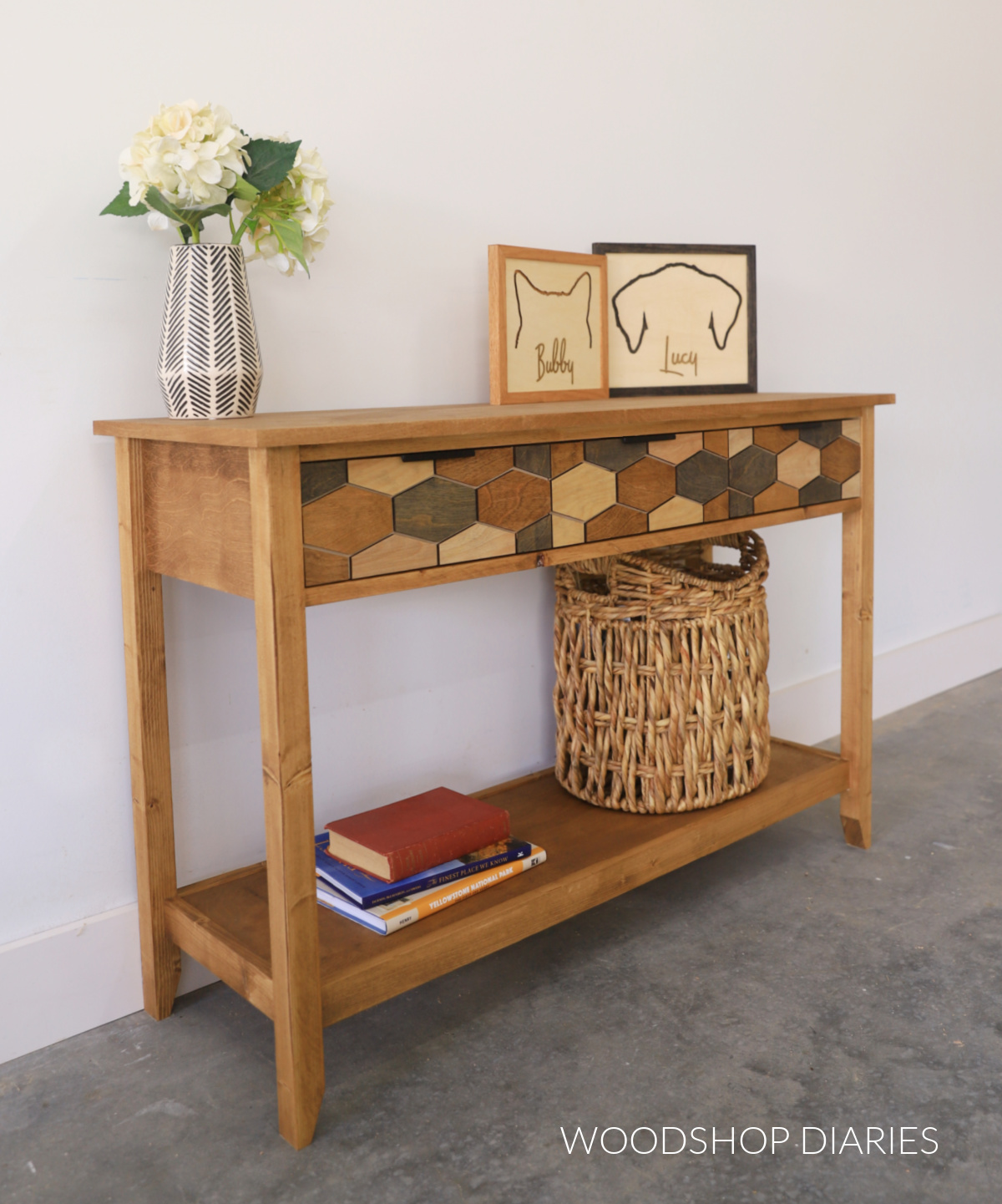 Completed DIY modern console table with drawers at top and a shelf at bottom. Drawer fronts have multicolor modern hexagon overlay design with black accented drawer pulls