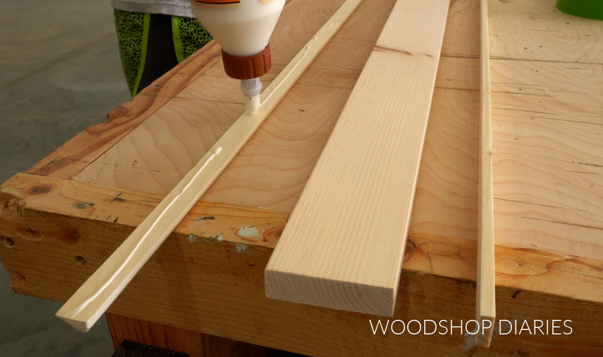 Shara Woodshop Diaries applying wood glue to chair rail molding to glue up picture frame