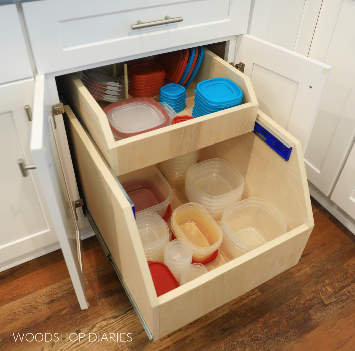 DIY cabinet organizer drawer installed into base kitchen cabinet with tupperware containers at bottom and lids in top drawer