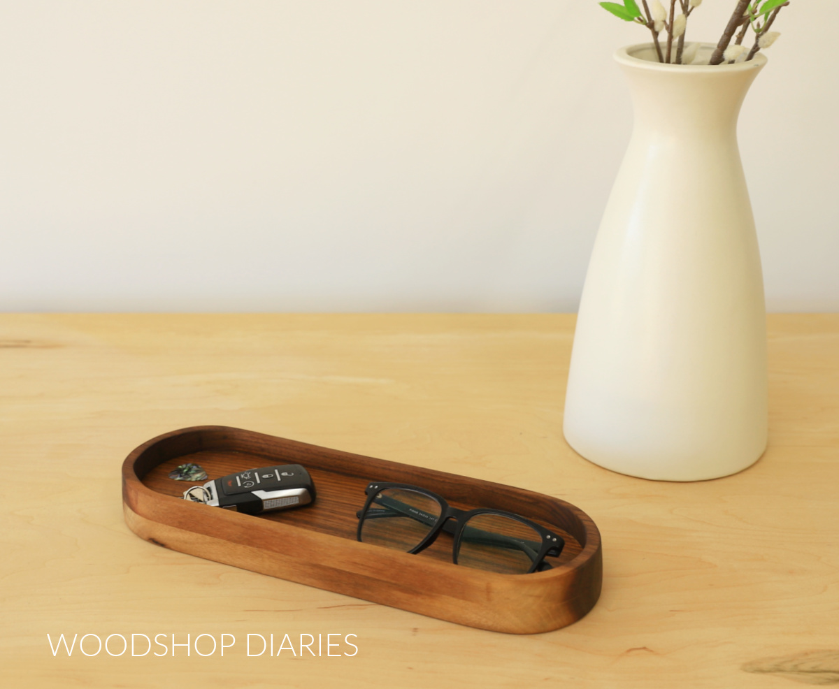 Finished DIY wooden catch all tray made from walnut with glasses, keys and guitar pick inside