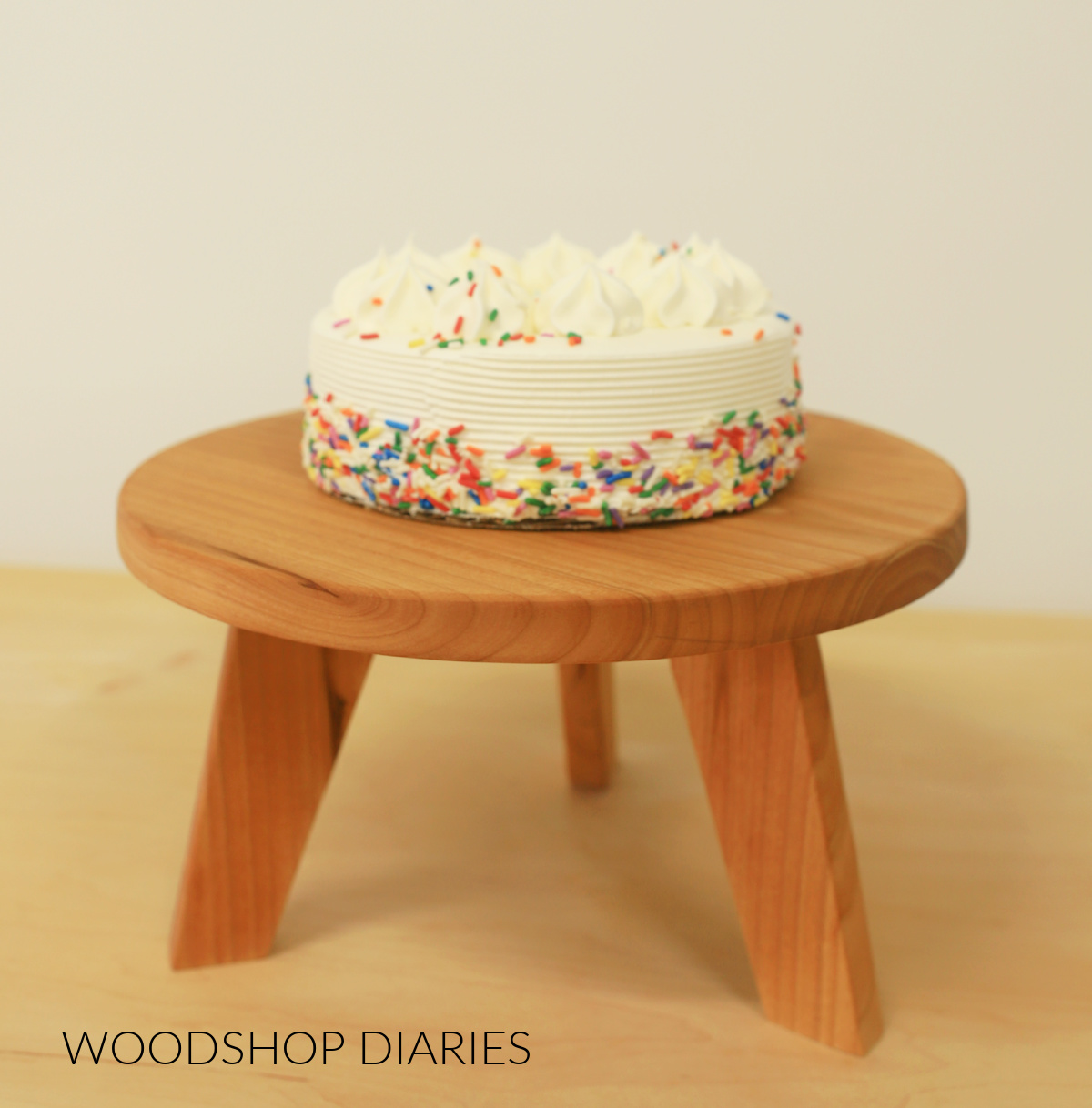 Cake stand with three modern legs with birthday cake on top