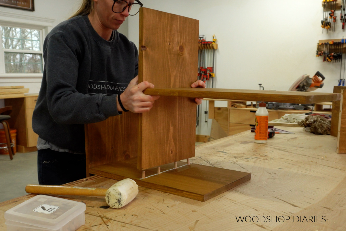 Shara Woodshop Diaries assembling angled bookshelf assembly with wood glue and dowels on workbench