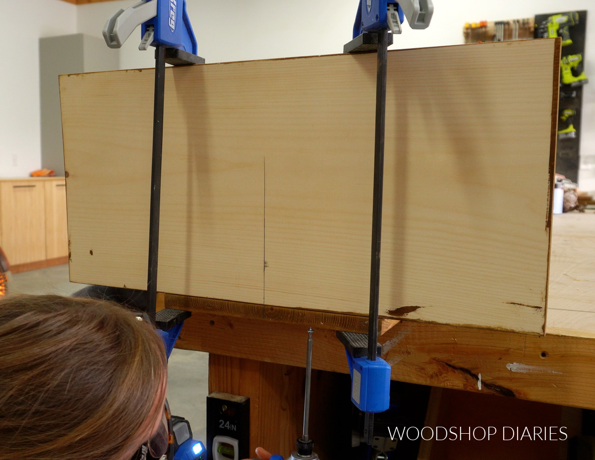 Close up of Shara Woodshop Diaries driving screws to attach back and bottom of bookshelf