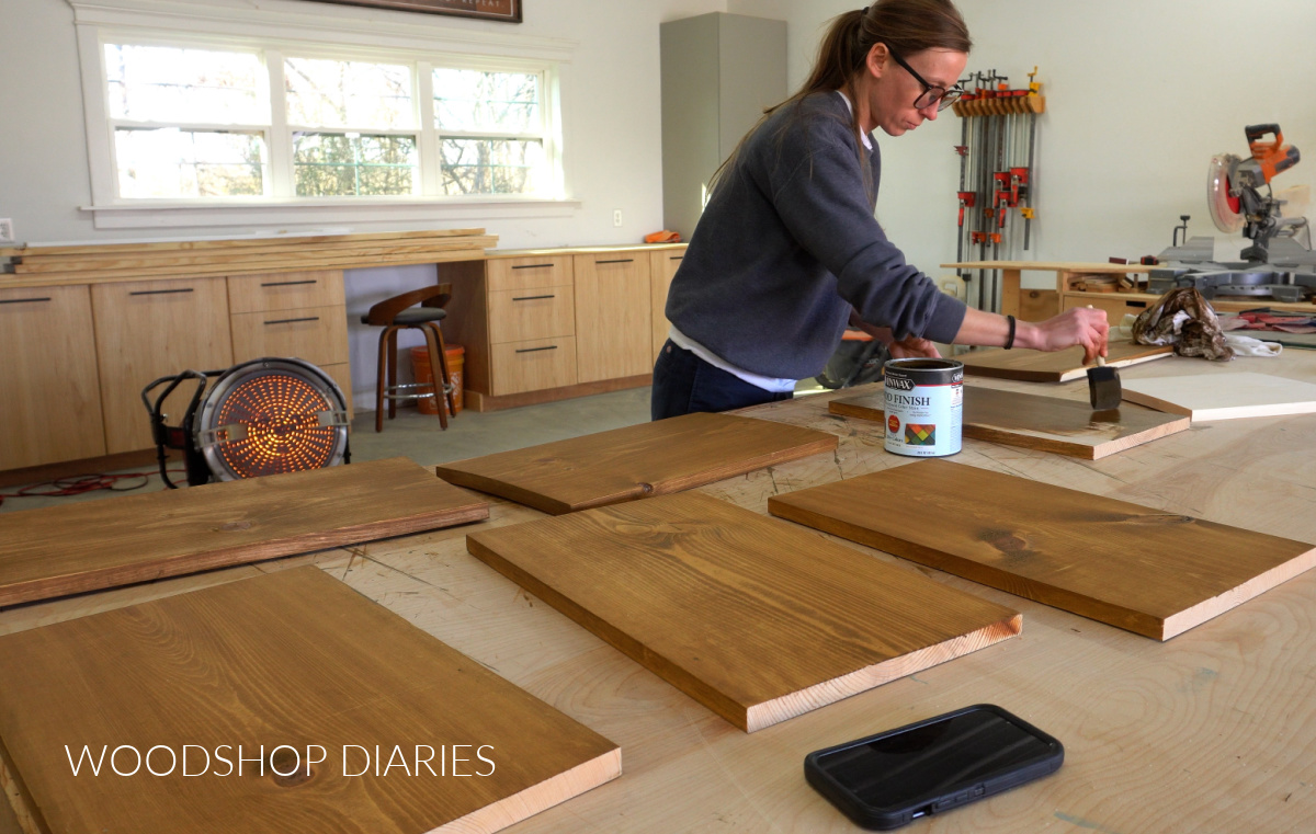 Shara Woodshop Diaries staining DIY angled bookshelf shelf boards on workbench with minwax water based stain