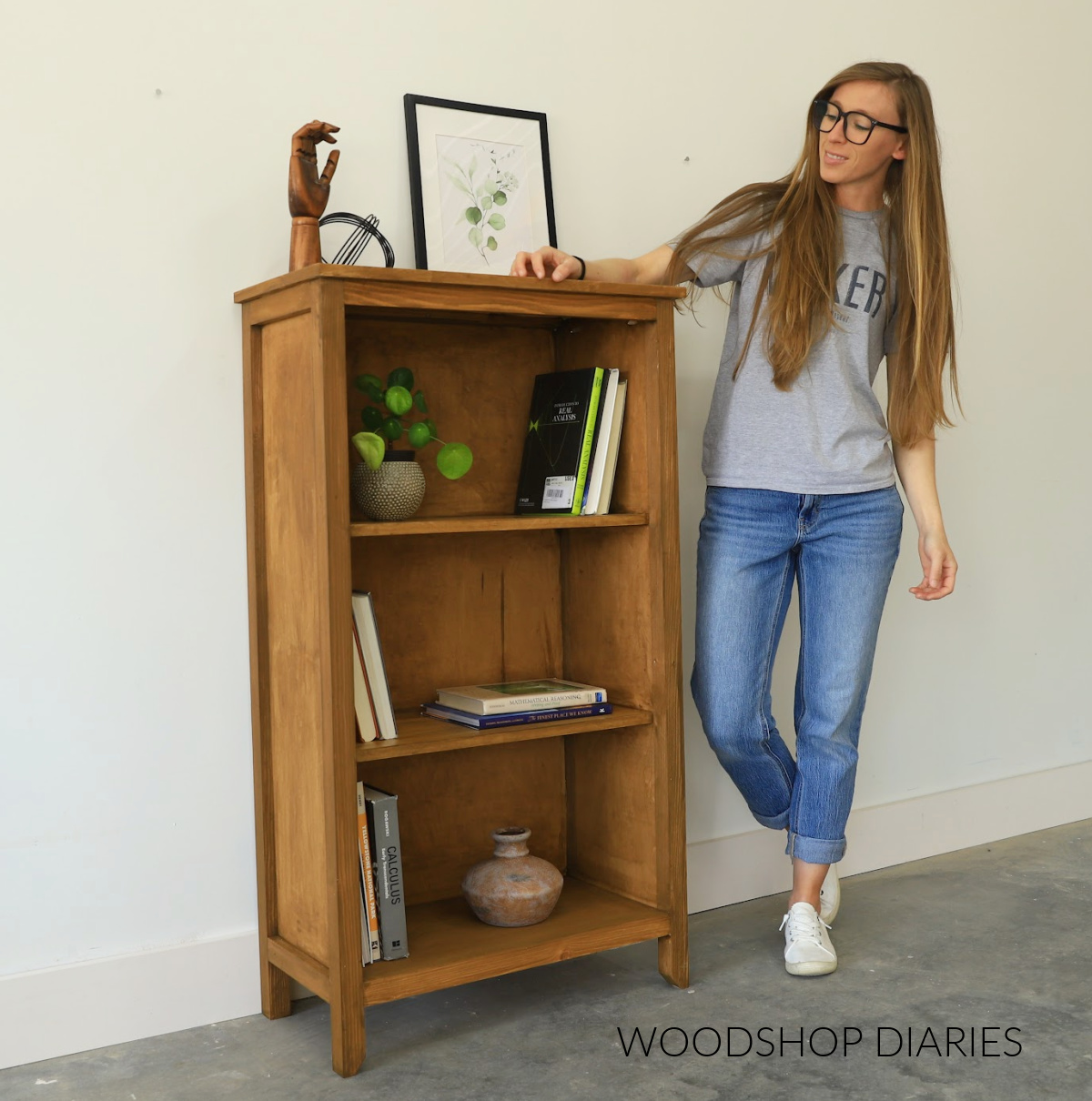 Shara Woodshop Diaries standing next to DIY rustic style small bookshelf stained in aged oak