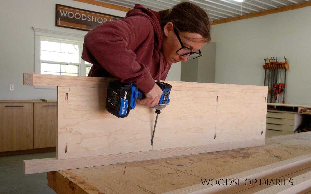 Shara Woodshop Diaries installing plywood side panel to 2x2 boards to make sides of bookshelf