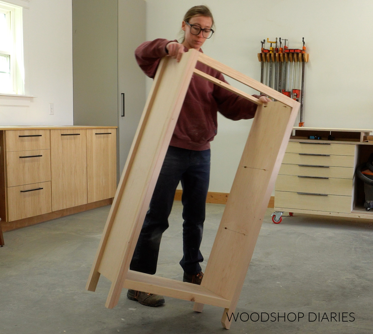 Shara Woodshop Diaries placing small bookcase frame on workshop floor