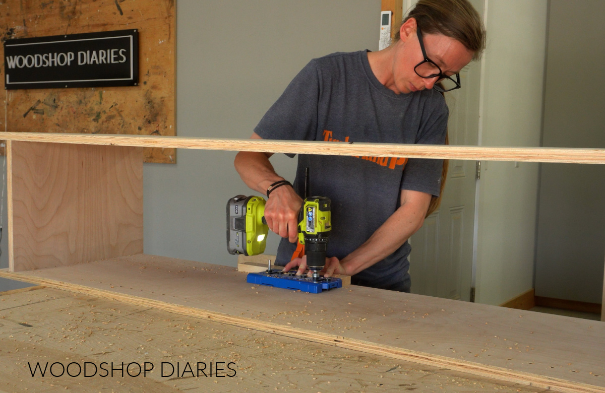 Shara Woodshop Diaries drilling shelf pin holes along cabinet sides